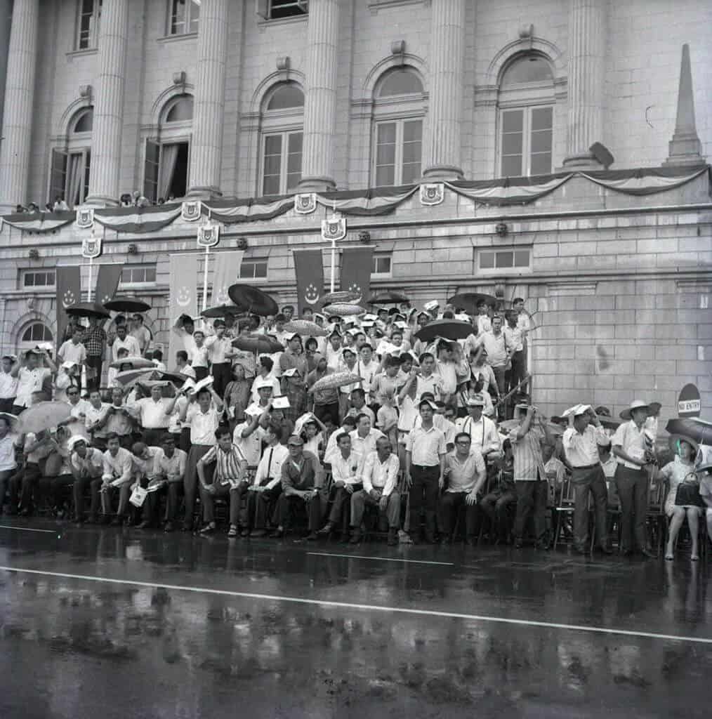 1968 National Day Parade. As the rain fell, some of the spectators managed to find shelter, but there was none available for the participants on the field.