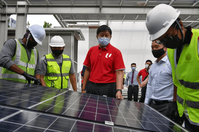 NTUC's Secretary-General Ng Chee Meng observes workers as they install a solar panel during the Career Development Plan for the Solar Industry event on Dec 17, 2020.